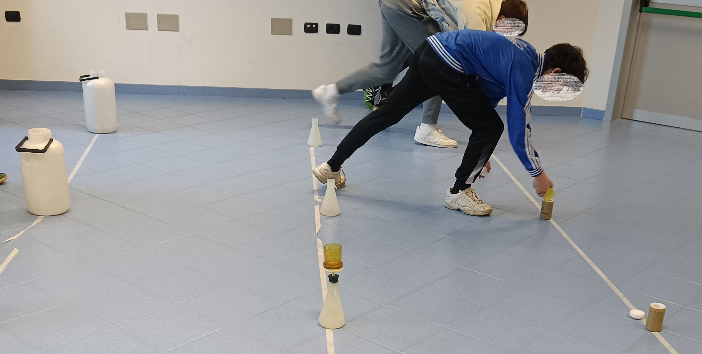 due ragazzi chinati che utilizzano strumentazione da laboratorio nell'ambito di un gioco a staffetta, con finalità di apprendimento