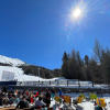persone che prendono il sole nel dehor di un locale situato sulle piste da sci di Pila , alberi, cielo azzurro e sole