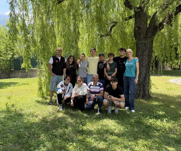 ragazzi e ragazze, docenti, esperti arpa insieme davanti ad un salice piangente, in posa per una foto di gruppo nel giardino dell'I.S. Manzetti