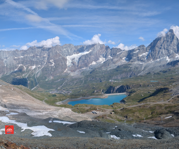 ambiente montano, rocce, lago, montagne in lontananza, chiazze di neve