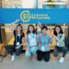 quattro ragazze accovacciate che indicano l'insegna EGU General Assembly
