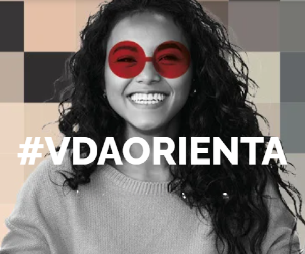 Locandina evento #vdaorienta: una ragazza che sorride, con i capelli ricci e occhiali rossi finti sul volto