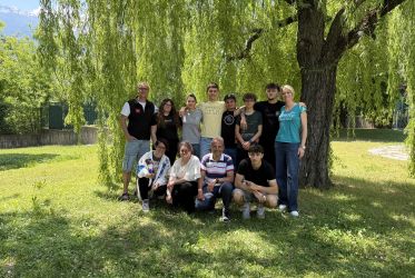 ragazzi e ragazze, docenti, esperti arpa insieme davanti ad un salice piangente, in posa per una foto di gruppo nel giardino dell'I.S. Manzetti
