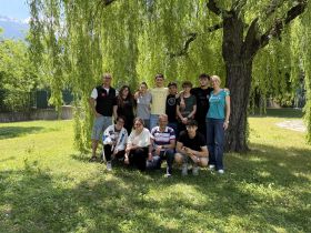 ragazzi e ragazze, docenti, esperti arpa insieme davanti ad un salice piangente, in posa per una foto di gruppo nel giardino dell'I.S. Manzetti