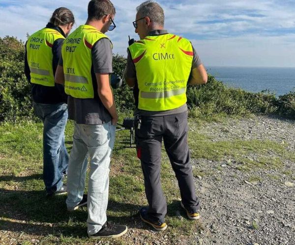 Tre piloti di droni che si stanno coordinando in zona collinare sul mare durante l'esercitazione di Spotorno