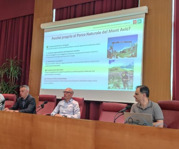 conferenza stampa di presentazione del progetto, 5 uomini seduti alle scrivanie, schermo con proiezione