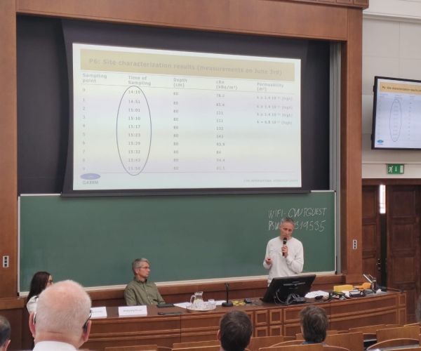 persone che ascoltano sedute in un'aula universitaria un uomo che parla di uno studio scientifico riguardante il radon