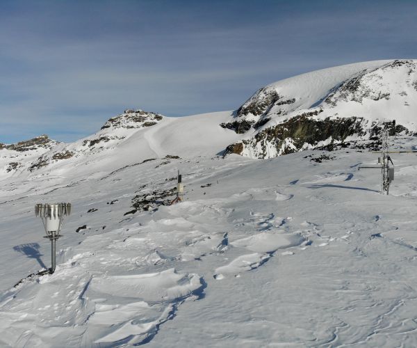alta montagna ricoperta di neve e strumenti posizionati per il monitoraggio del permafrost